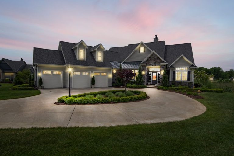 Modern suburban home in Fresno area beautifully lit with exterior landscape lighting at dusk for curb appeal