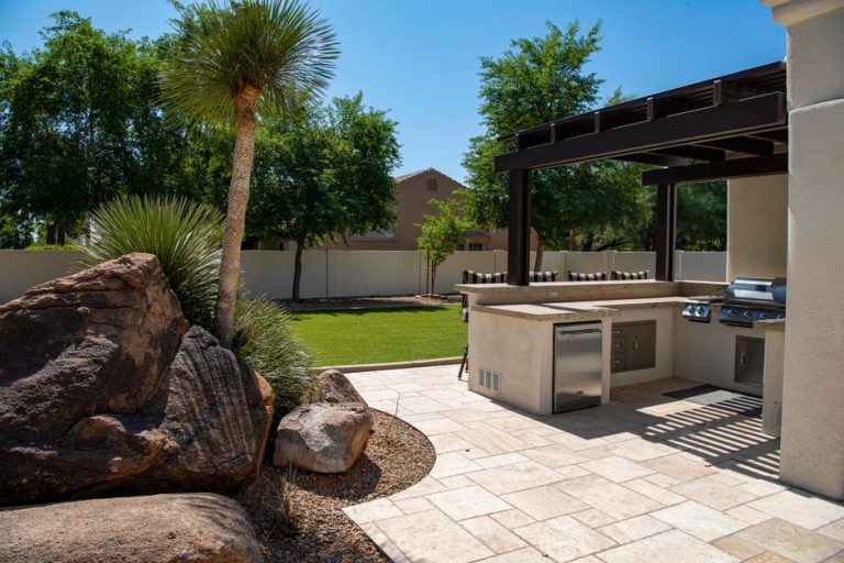 Travertine paver patio with outdoor kitchen and pergola in a Clovis, CA backyard landscaping project